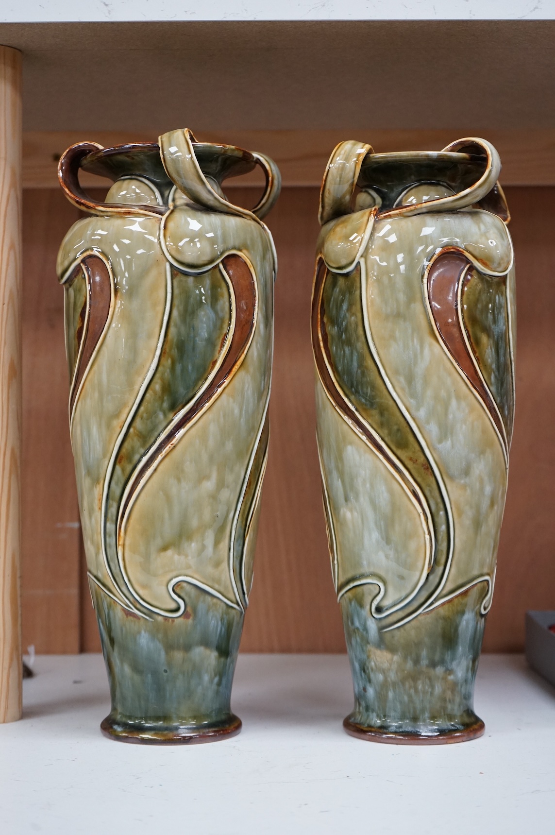 A pair of Royal Doulton, Art Nouveau vases by Frank Butler, incised and impressed marks to the bases, 37cm high